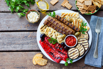 Traditional middle eastern, arabic or mediterranean meat kebab with grilled vegetables. Copy space. Top view.