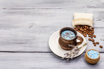 Trendy colored latte. Lavender and powdered aromatic sugar, coffee beans. Wooden boards background