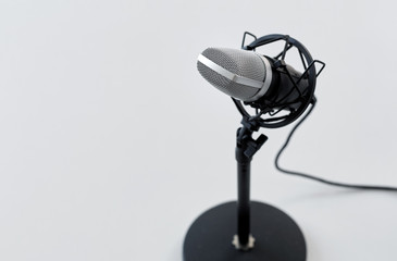 technology and audio equipment concept - close up of microphone on white background