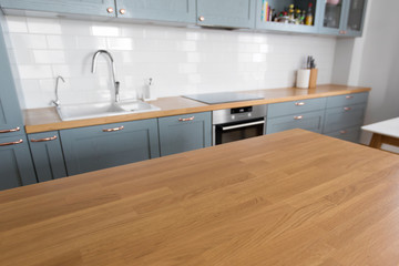 interior and cooking concept - modern kitchen counter and wooden table at home