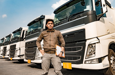 Portrait of Asian truck driver holding clipboard inspecting safety vehicle maintenance checklist...