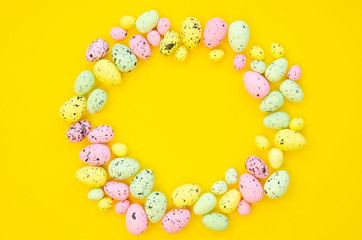Flat lay festive Easter quail eggs round shape frame isolated on yellow. Copy space mockup