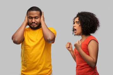 relationships and people concept - unhappy african american couple having argument over grey...