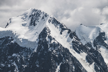 Atmospheric minimalist alpine landscape with massive hanging glacier on snowy mountain peak. Big...
