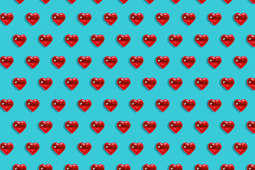 Valentine's day background. Pattern of glass red hearts on a blue background. Card minimalism, Symbol of love