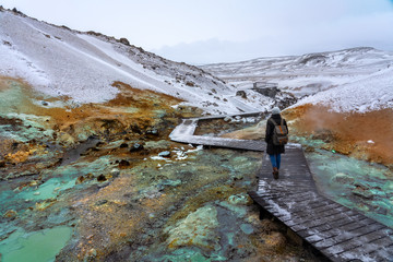 tourist woman on the path of colorful krysuvik seltun on reykjanes peninsula in Iceland