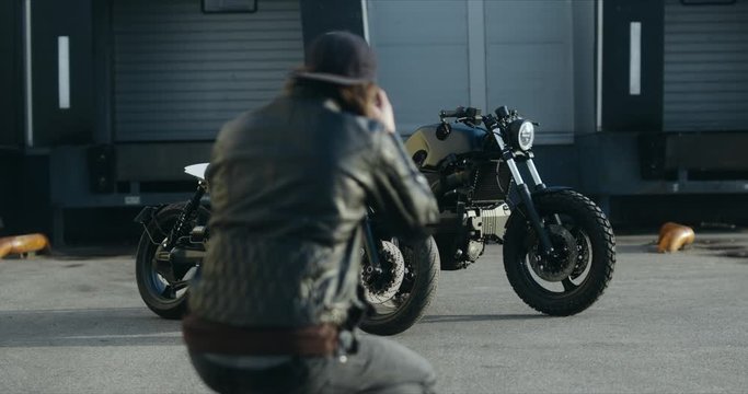 Photographer taking pictures of two custom built vintage cafe racer motorcycles in the street. 4K UHD RAW Graded footage