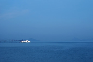 Lonely white ship in the blue sea and blue sky