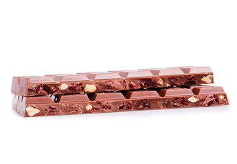 Pieces of milk chocolate bars with hazelnuts and cranberries isolated on white background with clipping path. Close-up of chocolate pieces