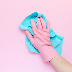 Employee hand in rubber protective glove with micro fiber cloth wiping wall from dust. Maid or...