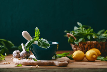 Pesto cooking culinary concept, front view of rustic kitchen table with pesto ingredients on it