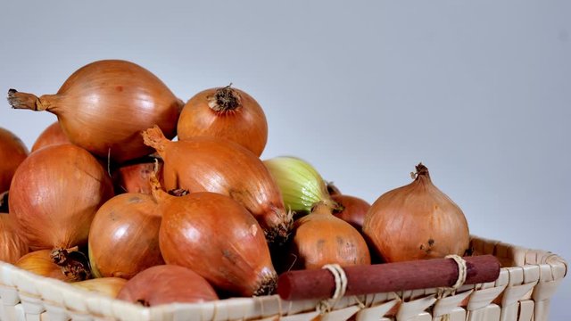 Obraz z ruchomej kamery cebuli w koszyku na białym 