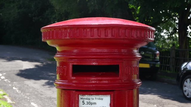 Posting a package at a Red Post box in the UK - Postbox / Mailbox Outside packet. Stock Video Clip Footage