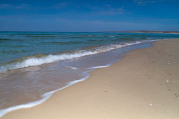 Fototapeta na wymiar View of blue sea waves at sandy beach. Horizon line. Caspian Sea, sandstone coast. ustyurt. Selective focus, long shutter speed