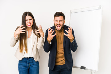 Young caucasian business couple isolated upset screaming with tense hands.