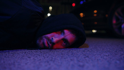 Ganster lying on ground police caught a bandit silen light in the dark at night police protection...