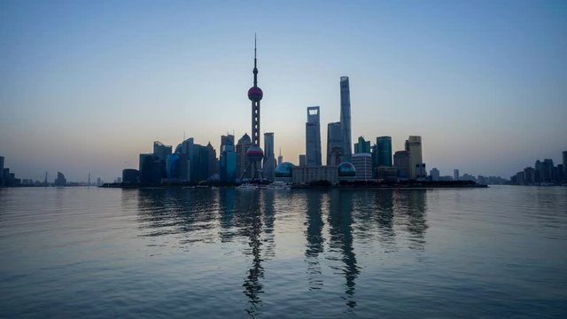 Time lapse of Shanghai skyline at sunrise, reflection on Huangpu River. Shanghai, China