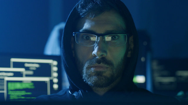 Portrait of hardworking pensive programmer working on data code in a software developing company office.