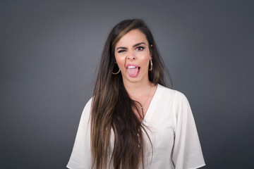 Body language. Disgusted stressed out pretty girl with straight fair hair posing against gray wall,...