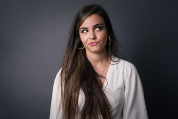Gloomy, wondering young woman face looking up lips together, being upset thinking about something...