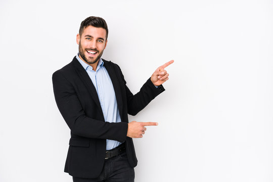 Young caucasian business man against a white background isolated excited pointing with forefingers away.