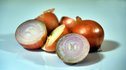 Przekrojone owoce cebuli umieszczone na talerzu na jasnym tle © JDziedzic