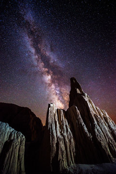 Odd clay formations are illuminated at night with stars in the sky and the Milky Way overhead in Cathedral Gorge State Park near Pioche, Nevada.