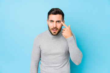 Young caucasian man against a blue background isolated showing a disappointment gesture with...