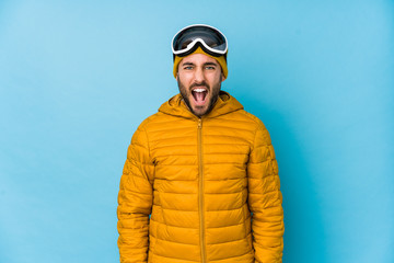 Young skier caucasian man isolated screaming very angry and aggressive.