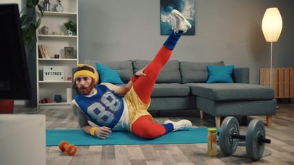 LOS ANGELES, CALIFORNIA, 10 OCTOBER, 2019: Funny fitness vlogger exercising and training at home. Sportive young man in retro clothes shooting a sports vlog. Motivation and sport concept.