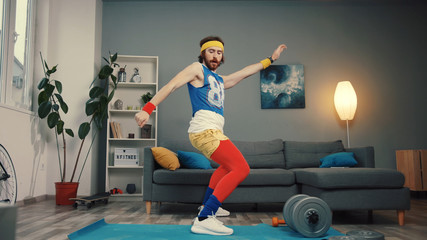 Stupid-looking funny athlete man in retro outfit dancing and warming up having an intense home...