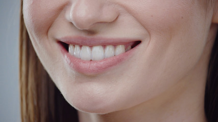 Woman mouth smiling happy beautiful soft lips showing healthy teeth dental lead by hand on the face...