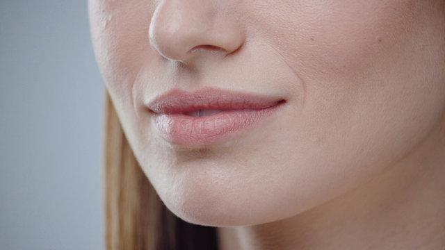 Close up young woman mouth smiling happy beautiful soft lips showing healthy teeth dental lead by hand on the face attractive female happy health cosmetics young slow motion
