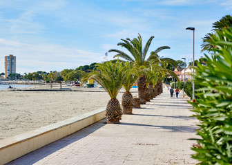 San Pedro del Pinatar palm trees lined promenade leading along sandy beach coastline of Mediterranean Sea. Murcia or Mursia city, Costa Cálida, province of Alicante. Spain