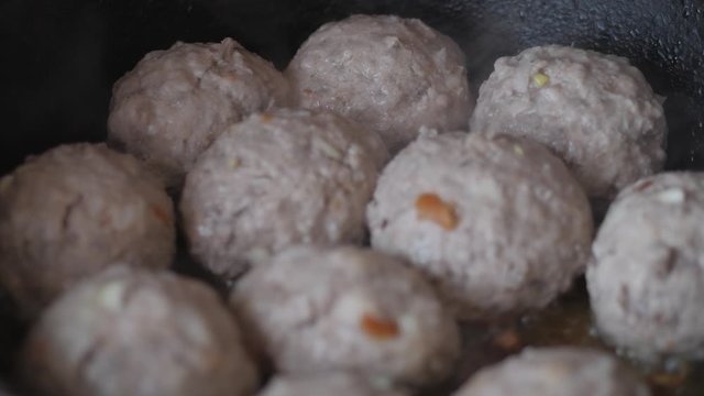 Home cooking. Roasting the meatballs in sunflower oil in a cast iron skillet.