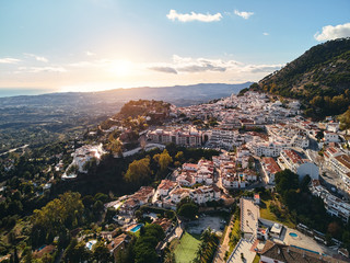 Aerial photo distant view charming Mijas pueblo, typical Andalusian white-washed mountain village, houses rooftops, small town located on hillside Province of Málaga, Costa del Sol, Europe, Spain - obrazy, fototapety, plakaty