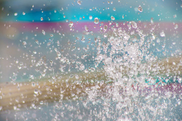 Macro photography of water drops.  Background is colorful, brightand blurry.