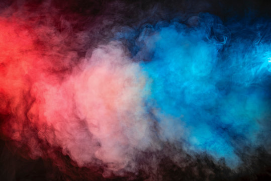 Backlit colorful smoke texture in red blue on a black background.
