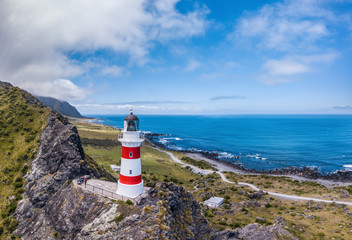 Lighthouse with red stripes on top of the rocks