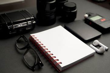 set work photographer, with white notebook with red detail, black glasses, wireless headphones, two...