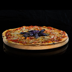 Italy hot pizza with cheese, tomatoes and purple basil isolated on black background