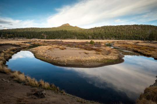 Beautiful clouds reflect in a scenic bend of the West Fork of the Carson River in Hope Valley, California