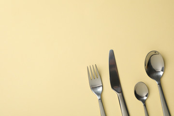 Cutlery on beige background, close up and space for text