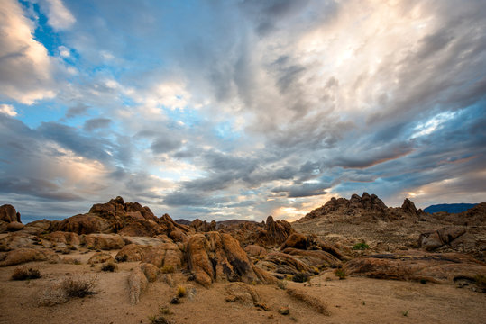 Dramatic clouds are illuminated over the Alabama Hills at sunrise in the desert of the Eastern Sierra near Lone Pine, California. © Tandem Stock