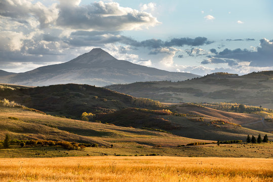 Golden light illuminates a beautiful mountain scene along Last Dollar Road in the San Juan Mountains along the Dallas Divide in between the towns of Telluride and Ridgeway, Colorado.