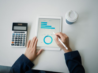 Business woman working on the charts to summary report on taplate to start up new business, analysis data charts and graphs concept.