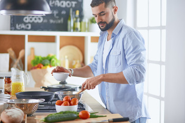 Smiling and confident chef standing in large kitchen