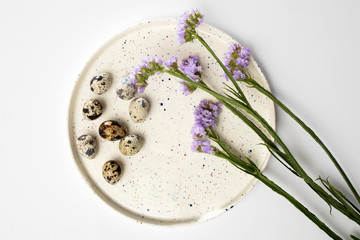 Limonium sinuatum Crystal Dark Blue. beautiful colorful fresh statice flower bouquet. Quail eggs on white dish. Easter card.