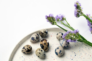 Quail eggs on a white dish. Easter card.