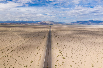 Aerial view of empty road passing through desert landscape